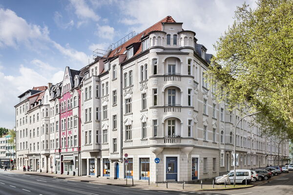 Straßenansicht eines verzierten Altbaus mit Erkern und Balkonen.