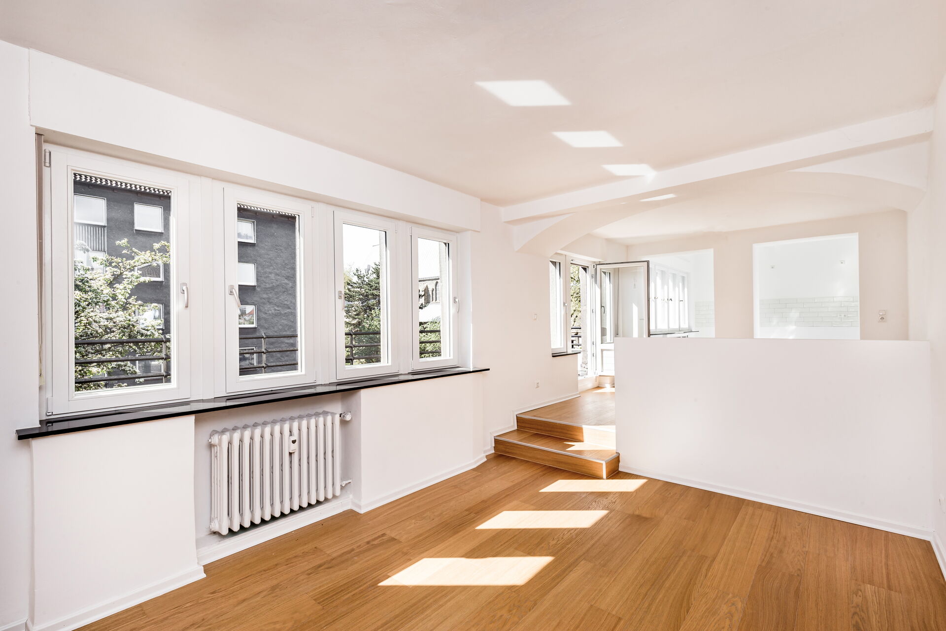 Innenraum Aufnahme einer modernen Wohnung mit viele Fenstern, Holzboden und weißen Wänden.